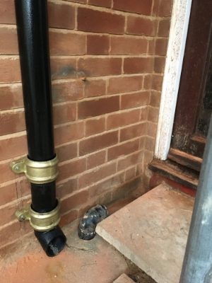 Black cast iron downpipe with eared shoe
